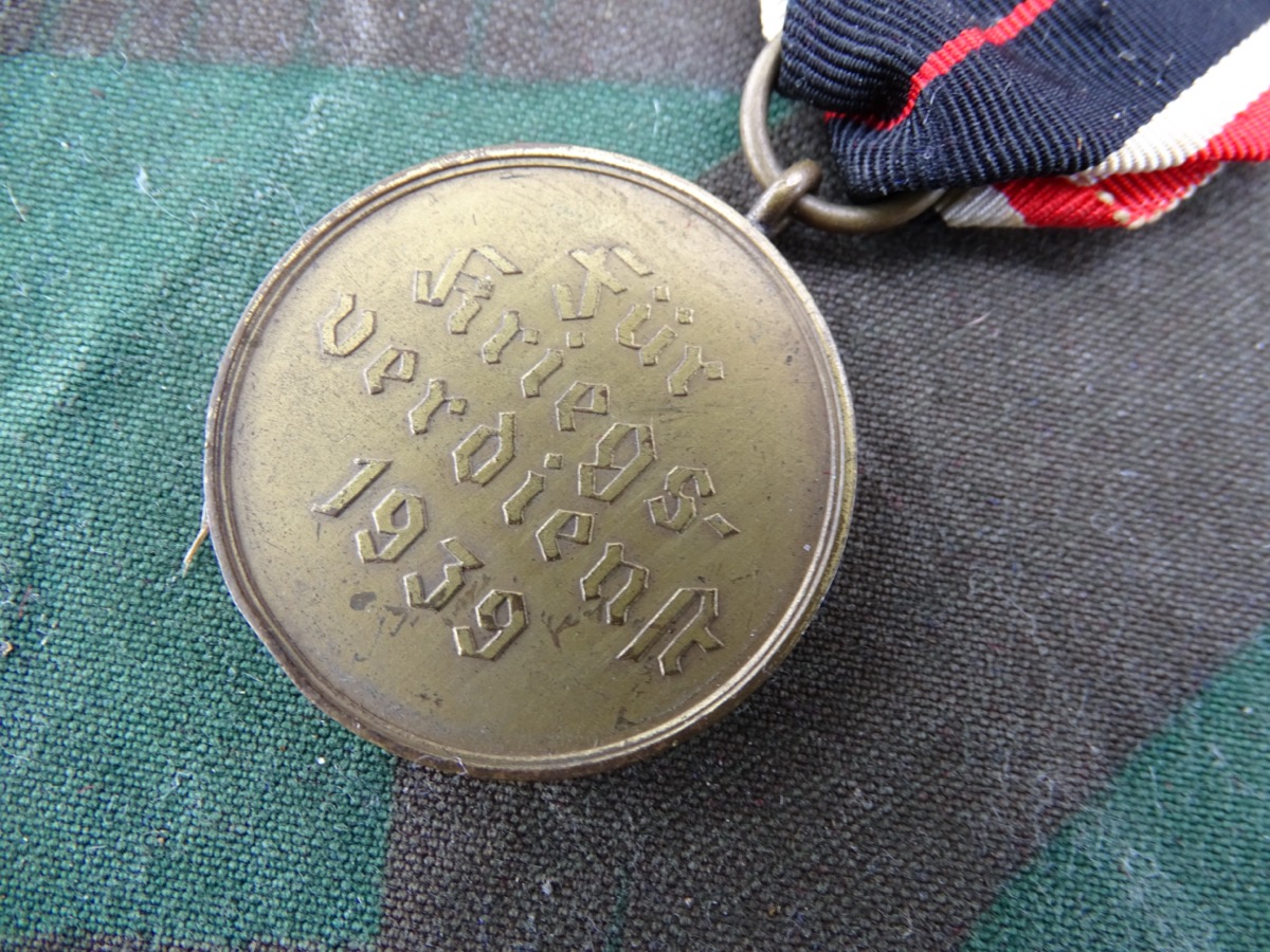 Kriegsverdienstmedaille, Buntmetall mit langem Bandabschnitt. 