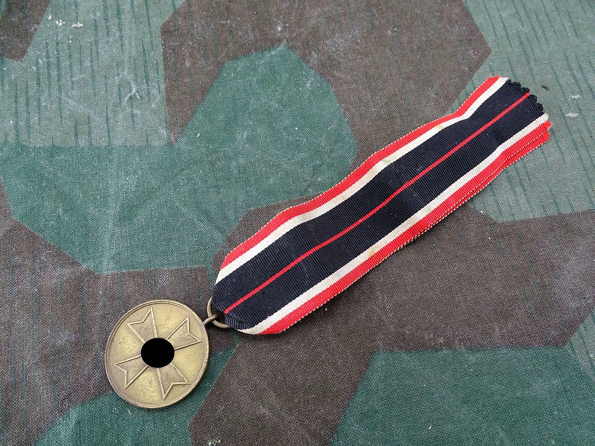 Kriegsverdienstmedaille, Buntmetall mit langem Bandabschnitt. 